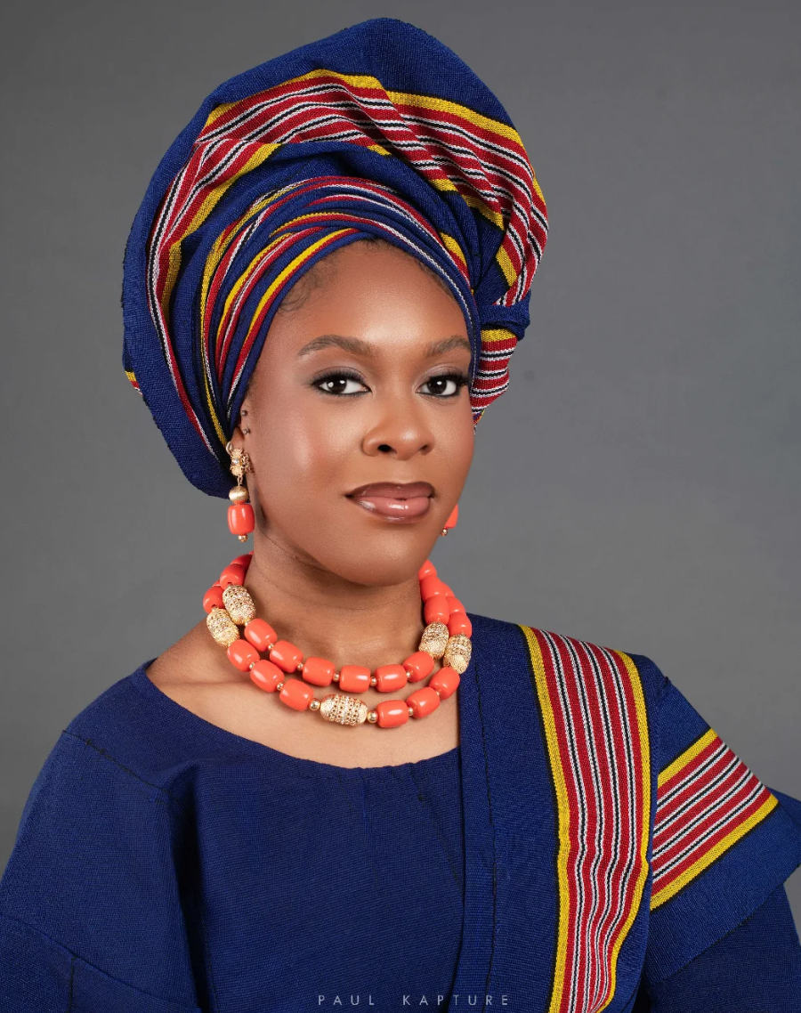Woman in blue and red traditional Nigerian attire with coral jewellery