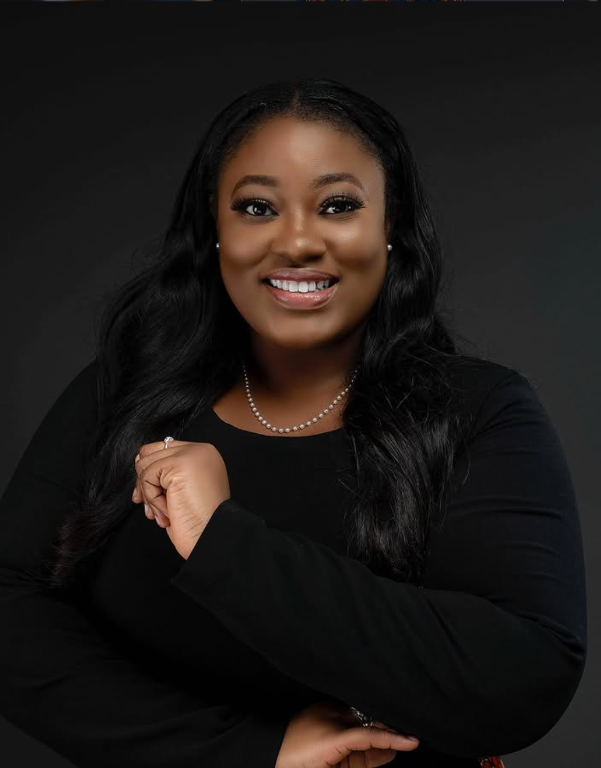 Studio headshot of a woman in black against a dark backdrop