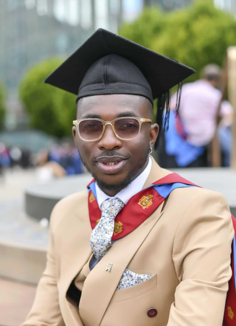 Graduate in a beige suit and mortarboard